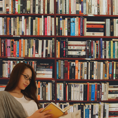 Woman Reading in a Library of Romance Books