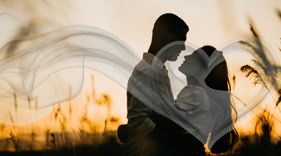 A couple embracing against a romantic sunset background.